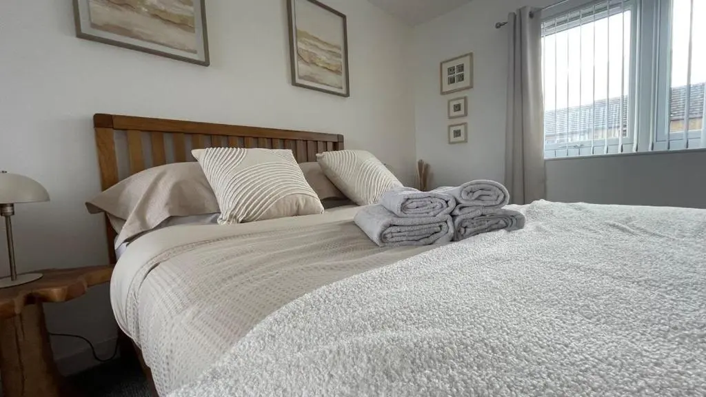 a bedroom with a bed with towels on it at The Den - by Caithness Luxury Apartments NC500 - 2 Bedroom holiday home - Sleeps Work teams upto 2 & holiday makers upto 4 in Wick