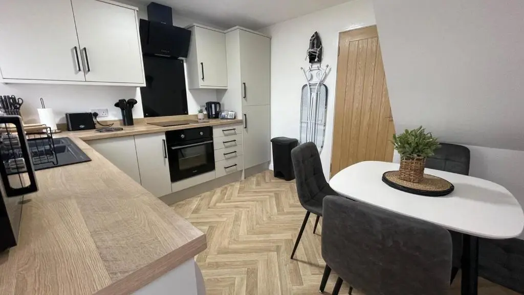 a kitchen with a table and chairs in a room at The Den - by Caithness Luxury Apartments NC500 - 2 Bedroom holiday home - Sleeps Work teams upto 2 & holiday makers upto 4 in Wick
