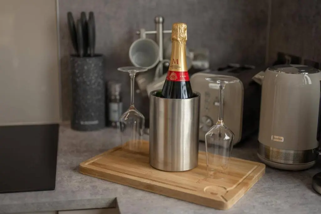 a bottle of champagne in a bucket on a counter at Migdale Heights - Luxury Cabins in The Highlands in Bonar Bridge