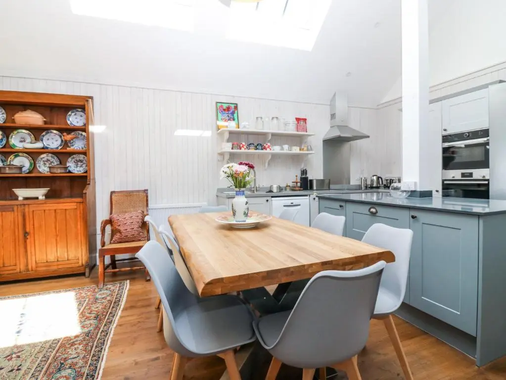 a kitchen with a wooden table and chairs at The Crannach in Blairgowrie