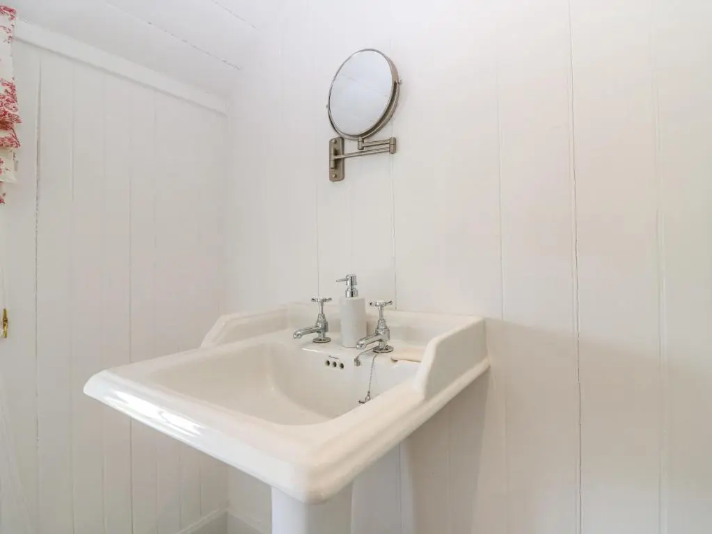 a white bathroom sink with a mirror on the wall at The Crannach in Blairgowrie