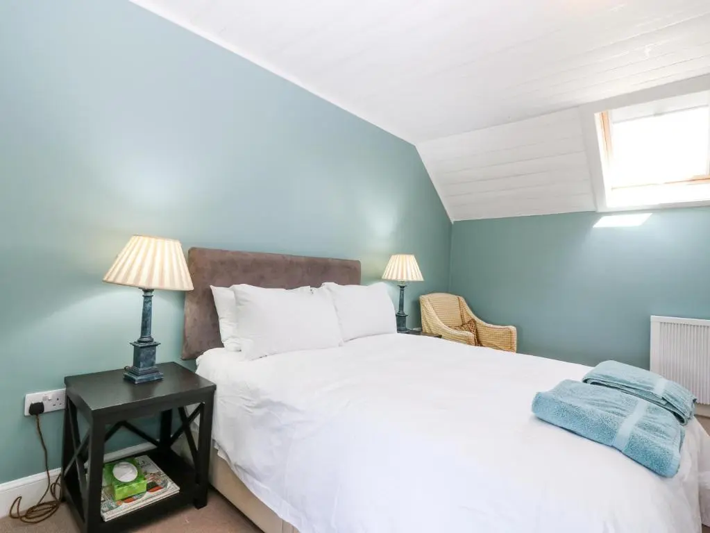 a bedroom with a white bed and a window at The Crannach in Blairgowrie
