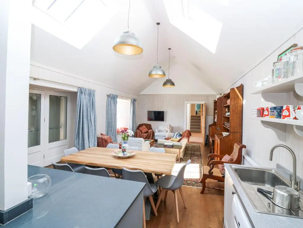 a kitchen and living room with a wooden table at The Crannach in Blairgowrie