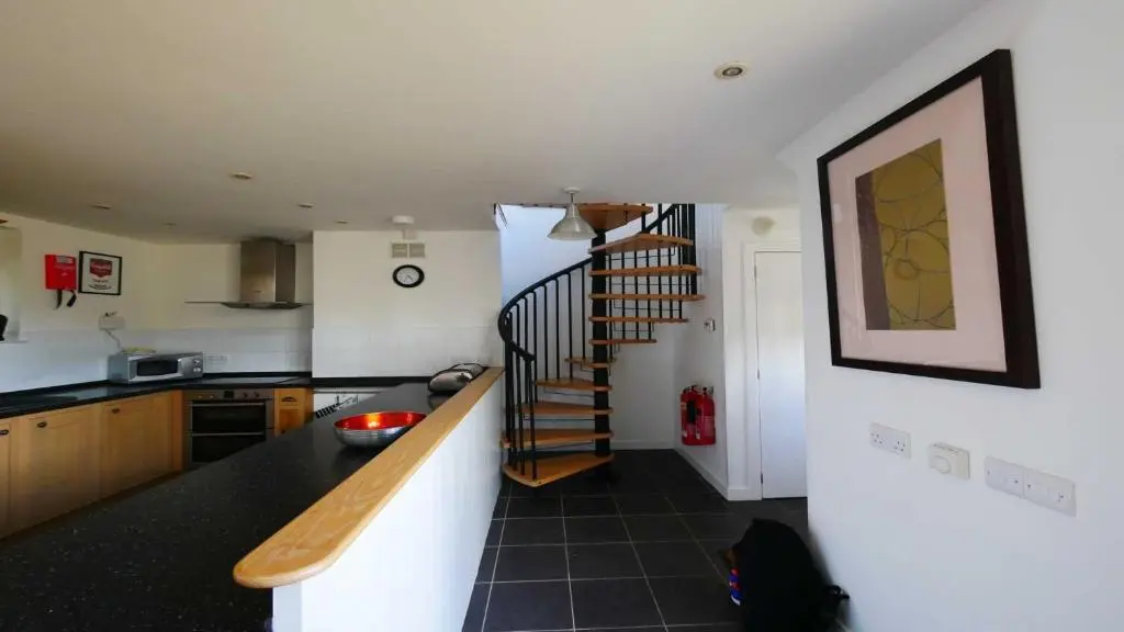a kitchen with a spiral staircase in a room at Coach House in Drumnadrochit