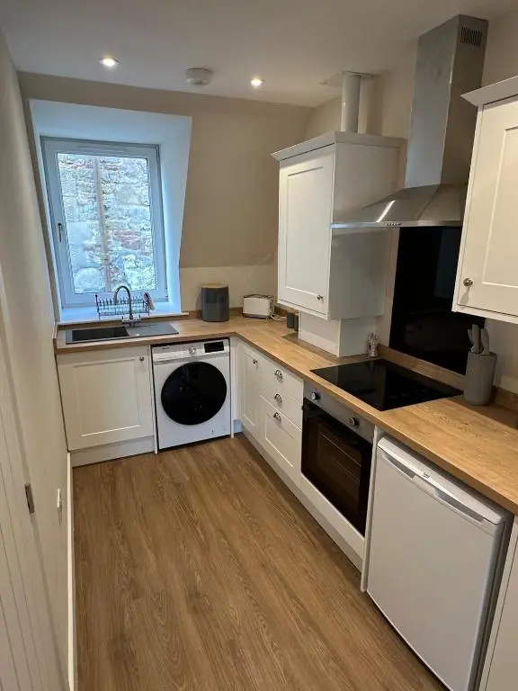 a kitchen with white cabinets and a sink at Highland Home on the Hill in Inverness