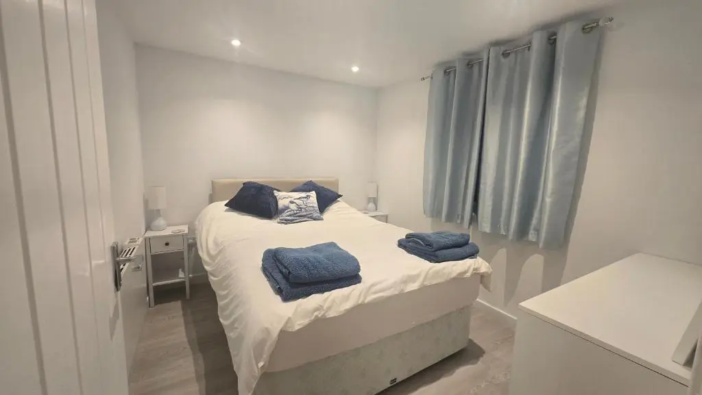 a bedroom with a bed with blue towels on it at Charlies Cottage in Inverness