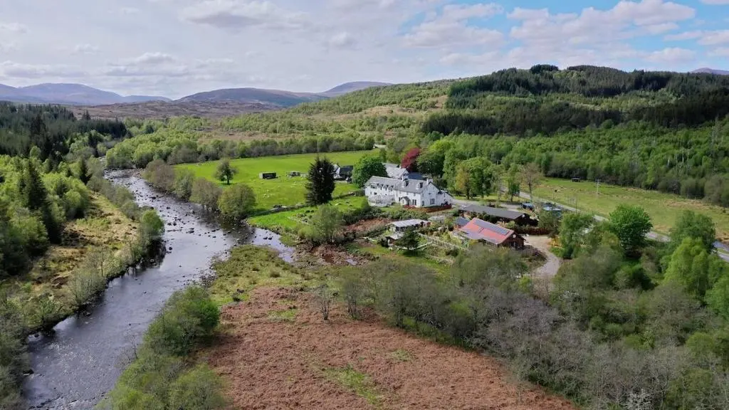 an aerial view of a house next to a river at Tonita in Garve