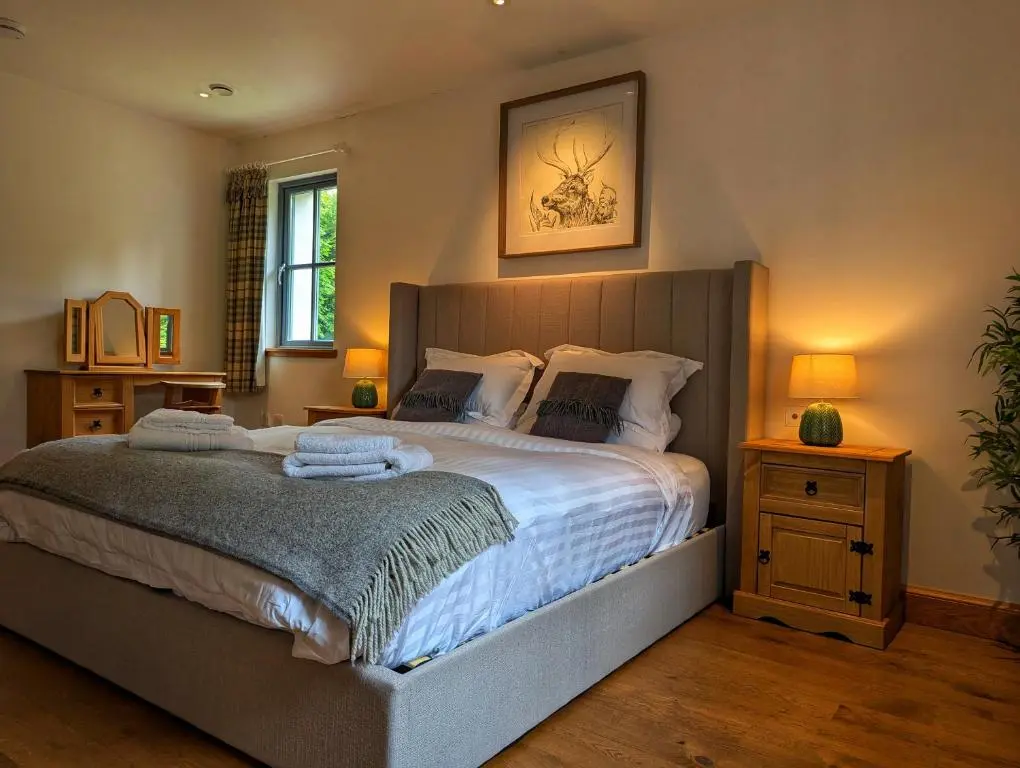 a bedroom with a large bed with towels on it at Logies Croft in Kellas