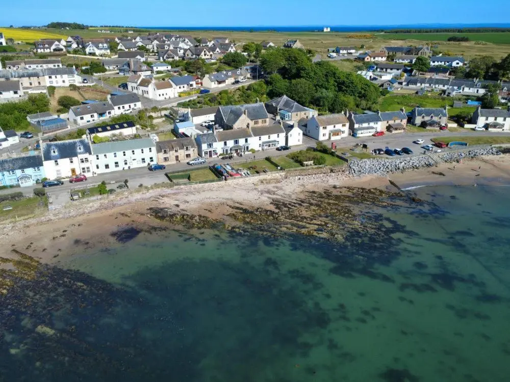 an aerial view of a beach with a group of houses at The Castle Hotel NR TAIN in Portmahomack