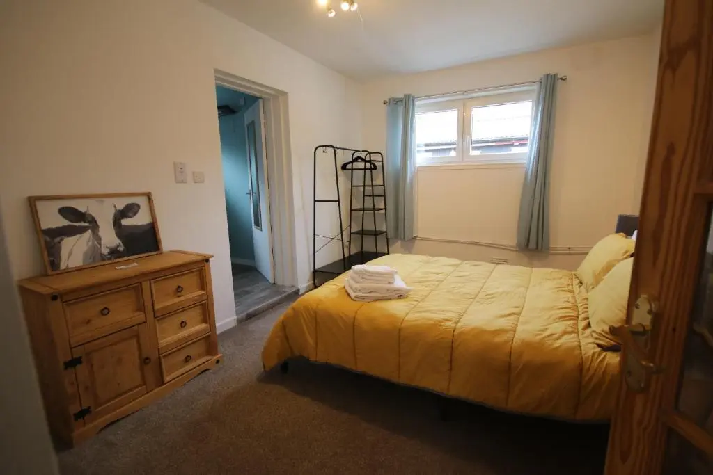 a bedroom with a bed and a dresser and a window at Owl View in Garve