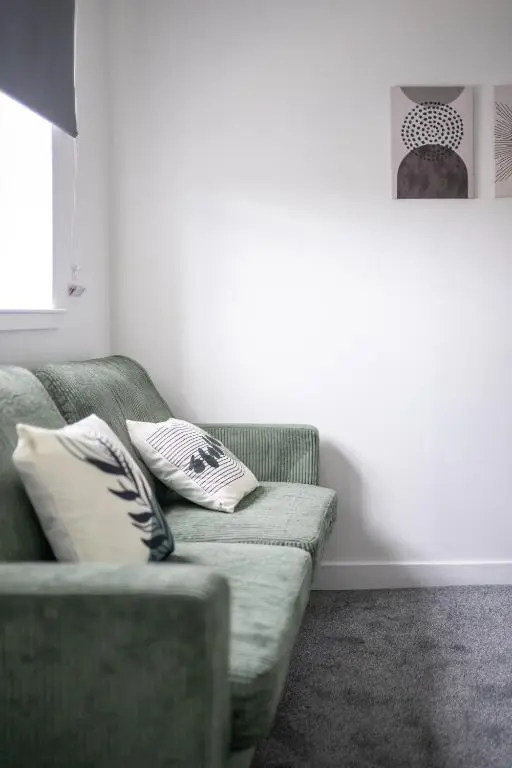 a living room with a green couch with two pillows at 1 BDR Apartment At Caledonia Luxe Stays Short Lets & Serviced Accommodation Inverness in Inverness