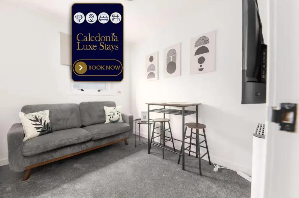 a living room with a couch and a table and stools at Dram Apartment in Inverness