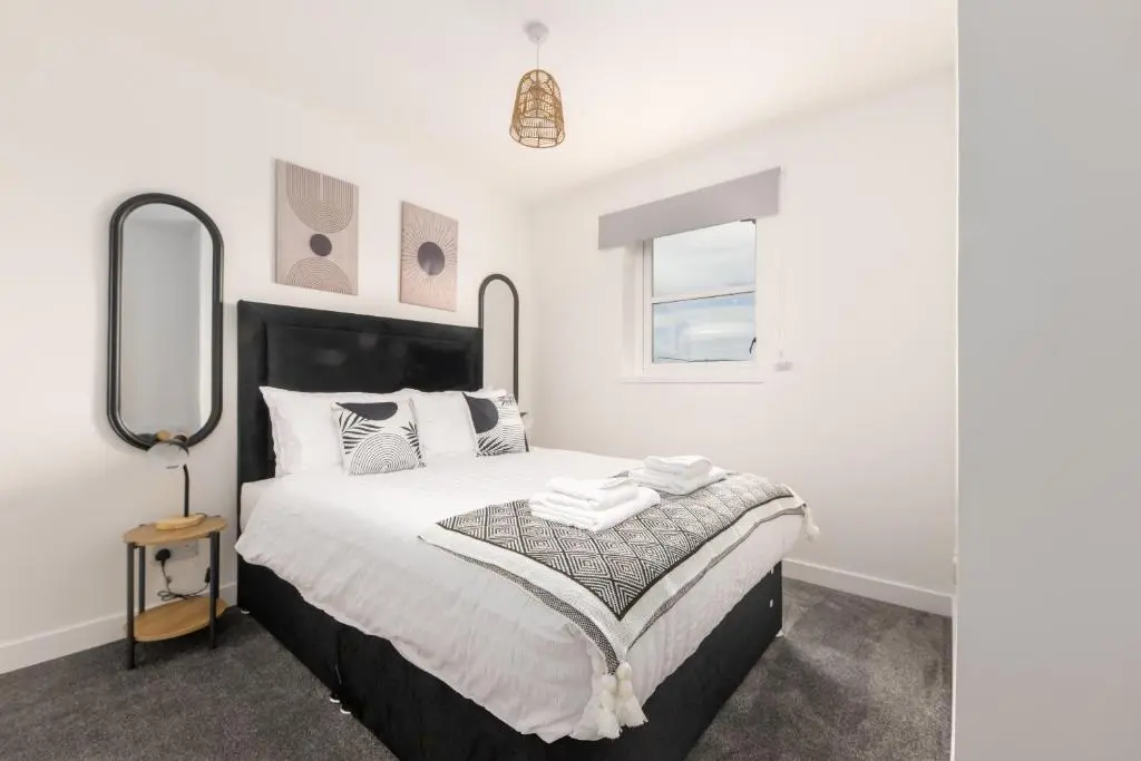 a bedroom with a large bed with a mirror at Dram Apartment in Inverness