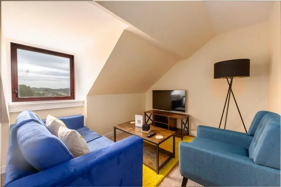 a living room with two blue couches and a television at 2 BDR Apt At Caledonia Luxe Stays Short Lets & Serviced Accommodation Inverness in Inverness
