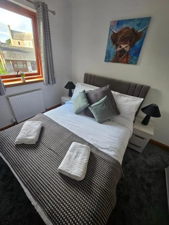 a bedroom with a bed with two towels on it at Forres Nights in Forres