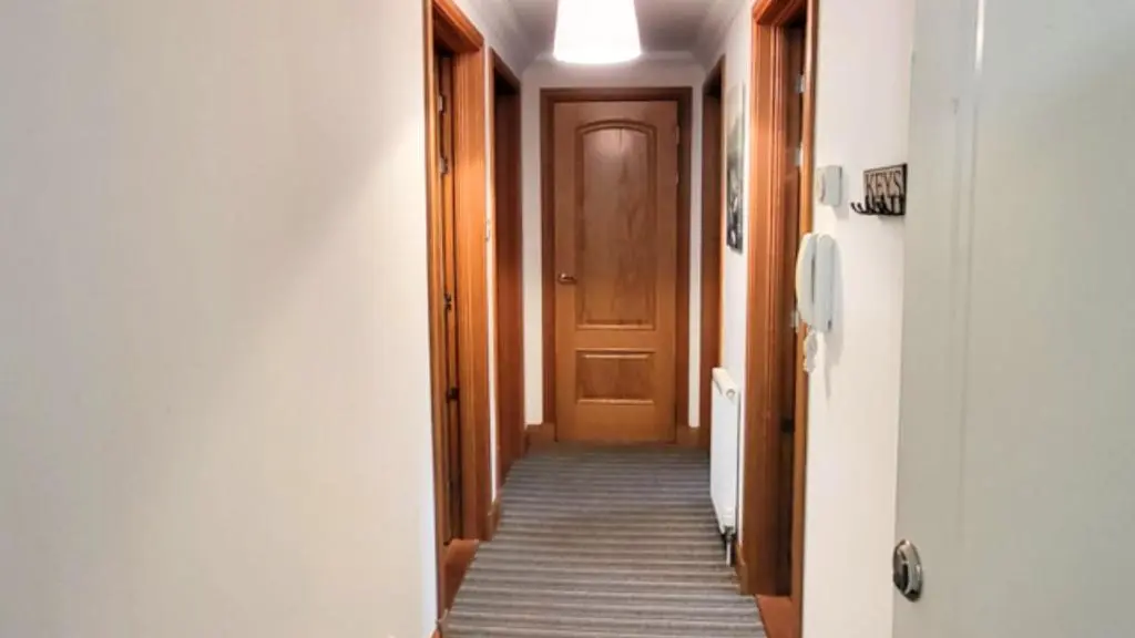 a hallway with a wooden door and a carpeted floor at Forres Nights in Forres