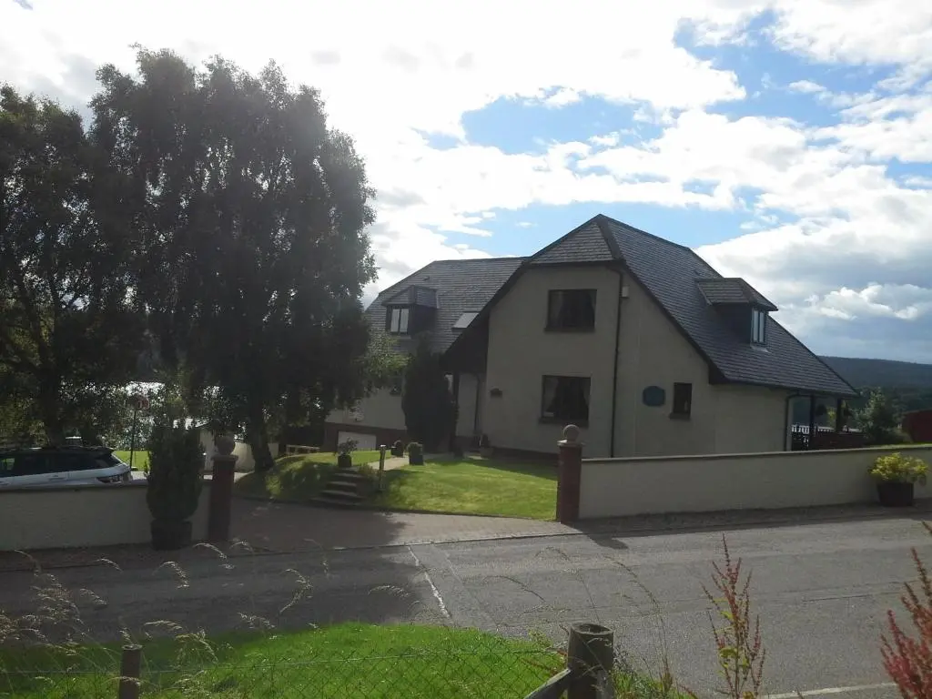 a white house with a black roof at Kimcraigan B&B in Brackla