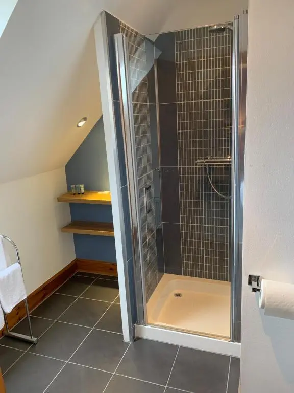 a shower with a glass door in a bathroom at Kimcraigan B&B in Brackla
