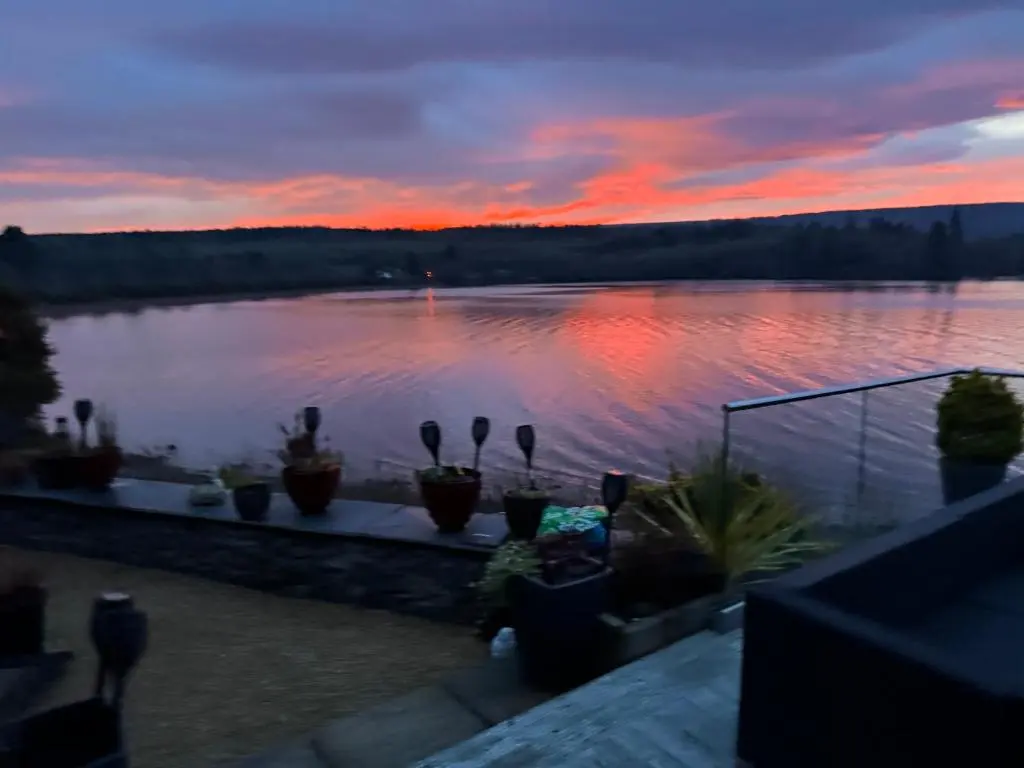 a sunset over a body of water with potted plants at Kimcraigan B&B in Brackla