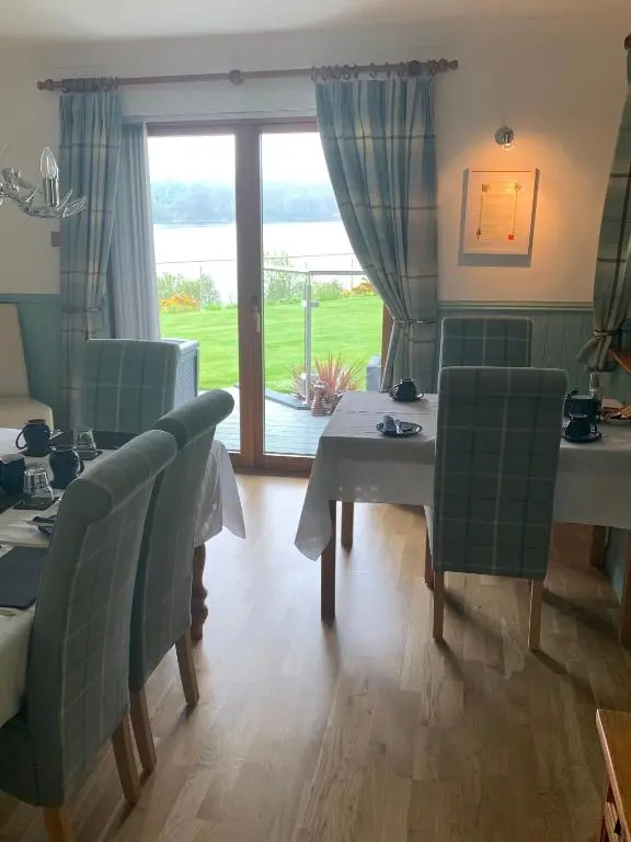 a dining room with a table and chairs and a window at Kimcraigan B&B in Brackla
