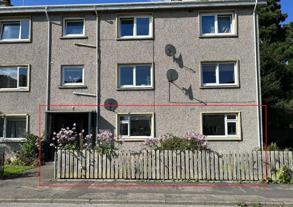 a brick building with windows and a fence at Cosy Flat Close to City Centre Ideal for Families in Dalneigh