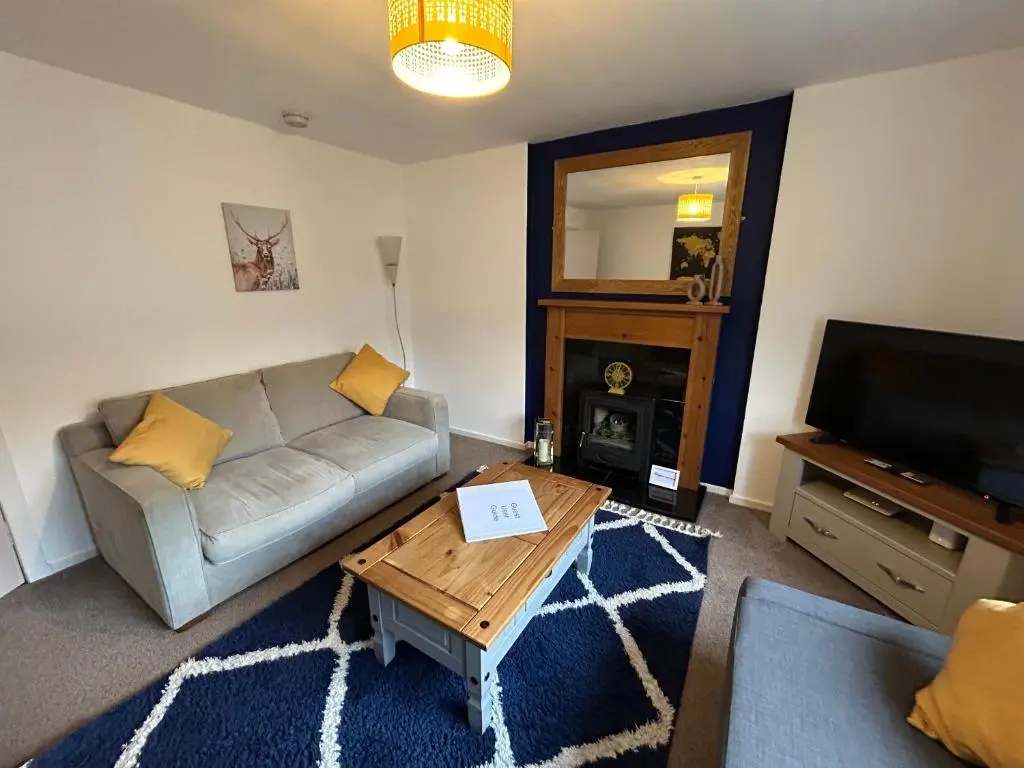 a living room with a couch and a coffee table at Cosy Flat Close to City Centre Ideal for Families in Dalneigh