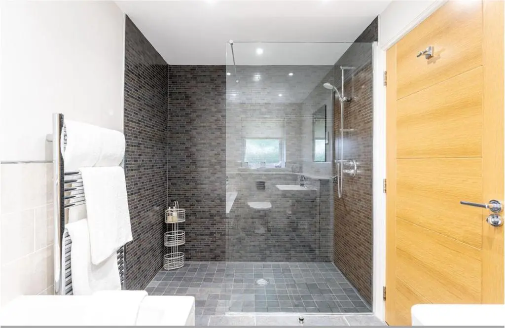 a bathroom with a shower with a glass door at Sandown House in Nairn