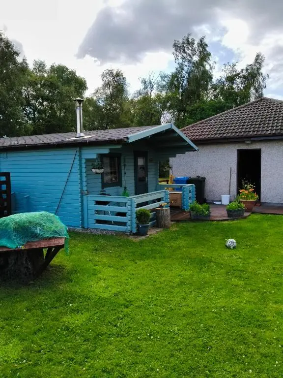 a blue house with a yard in front of it at Emili Fois in Tore