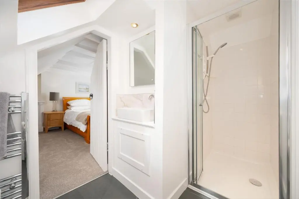 a bathroom with a walk in shower next to a bedroom at Soundwaves, Seatown, Gardenstown in Gardenstown