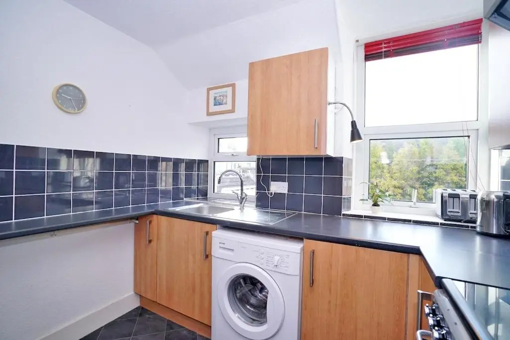 a kitchen with a washing machine and a sink at Bright and cosy central flat in Inverurie in Inverurie