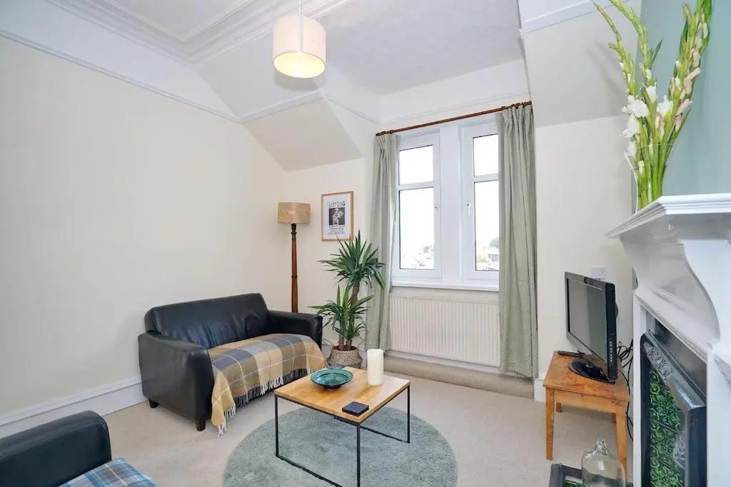 a living room with a couch and a tv at Bright and cosy central flat in Inverurie in Inverurie