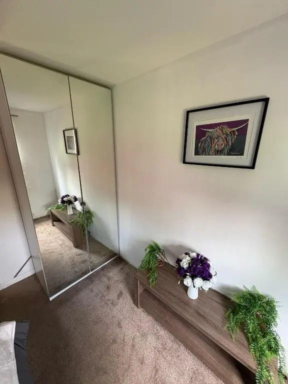 a room with a mirror and flowers on a table at Cloverdale Aparthotel in Aberdeen