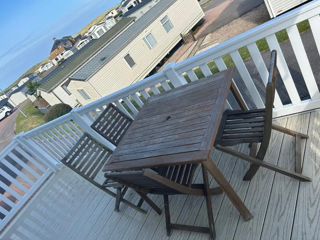 a wooden chair sitting on top of a deck at Parkview holiday lodge in Lossiemouth