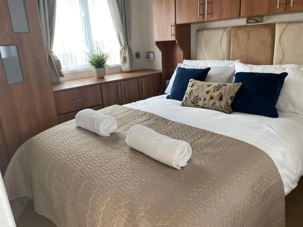 a bedroom with two white towels on a bed at Number 28 Dornoch Firth Caravan Park in Dornoch