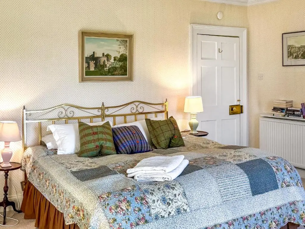 a bedroom with a large bed with pillows on it at The Cottage At Mains House in Tain