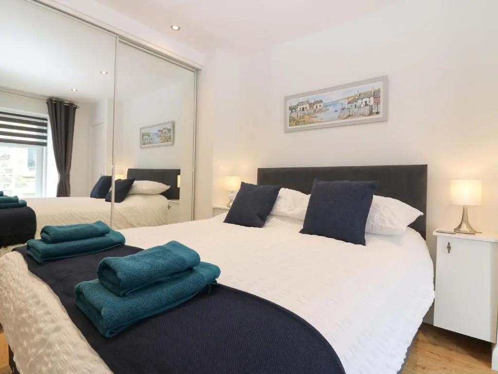 a bedroom with a large white bed with blue pillows at 3 Caroline Place in Fraserburgh
