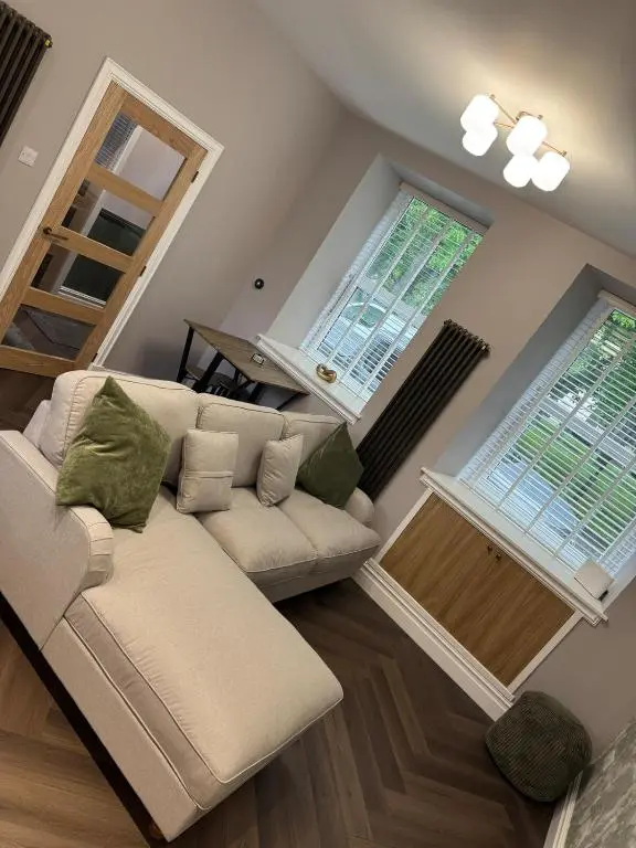 a living room with a couch and two windows at Luxury central townhouse in Wick