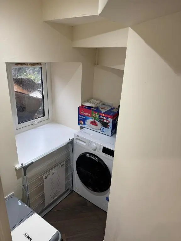 a small kitchen with a washing machine and a window at Luxury central townhouse in Wick