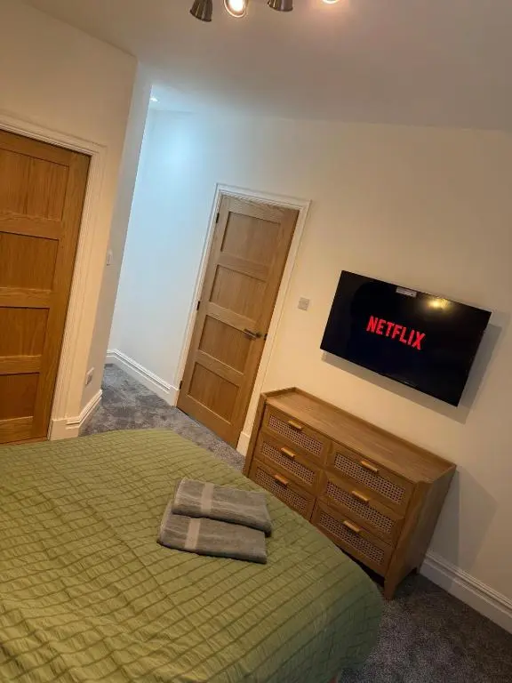 a bedroom with a bed and a television on the wall at Luxury central townhouse in Wick
