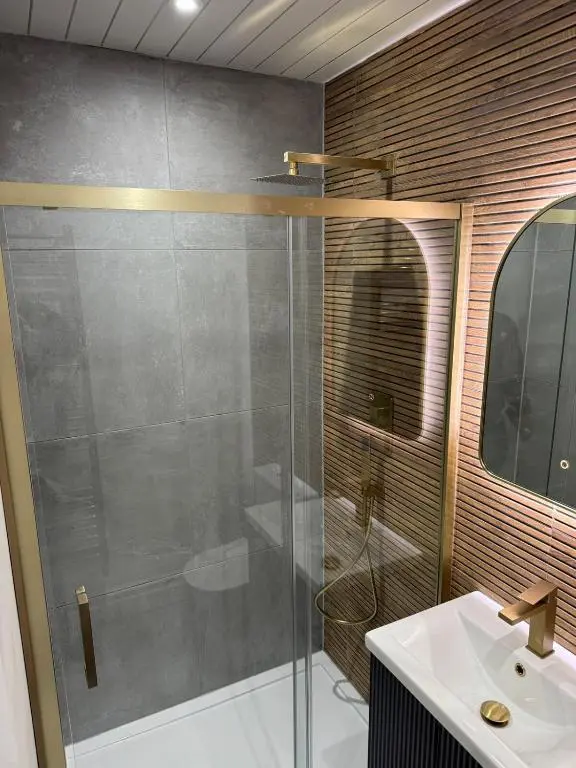a bathroom with a glass shower and a sink at Luxury central townhouse in Wick