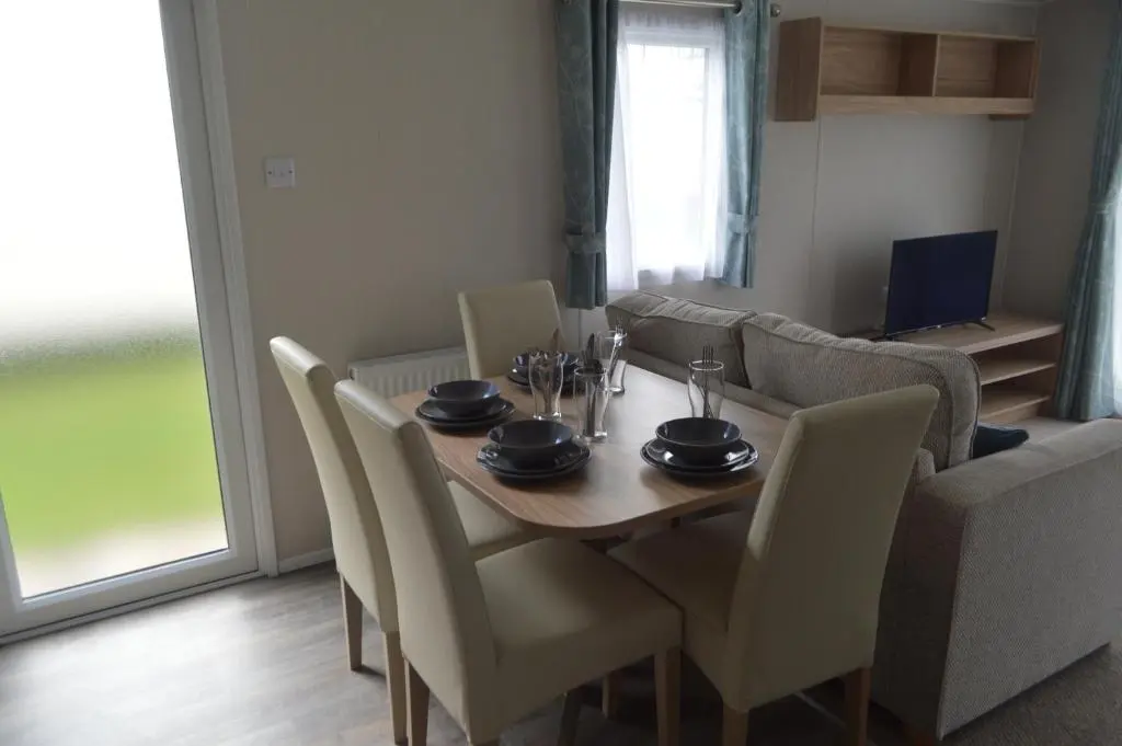 a dining room with a wooden table and chairs at B9 at The Old Mill Holiday Park in Dyke