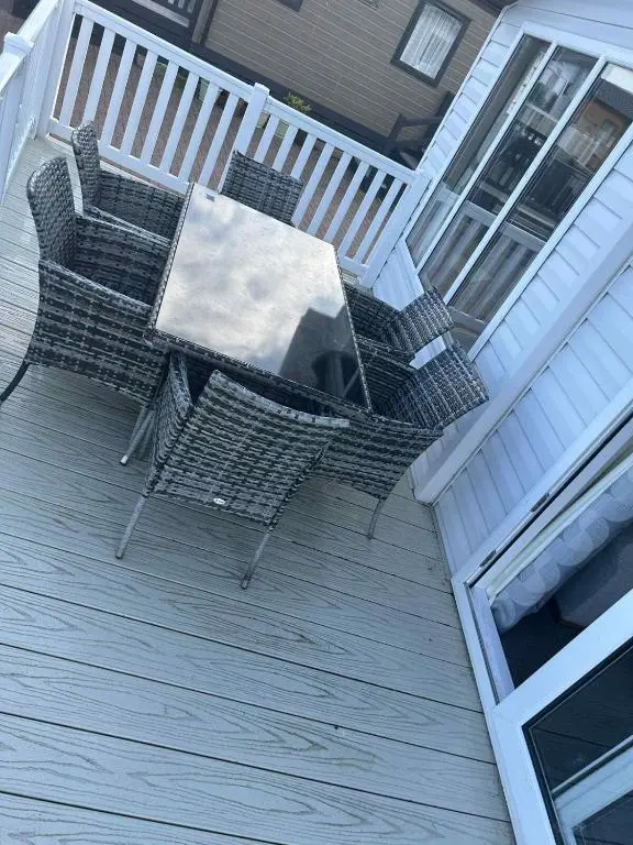 an outdoor table and chairs on a deck at Clearwater Lodge in Lossiemouth
