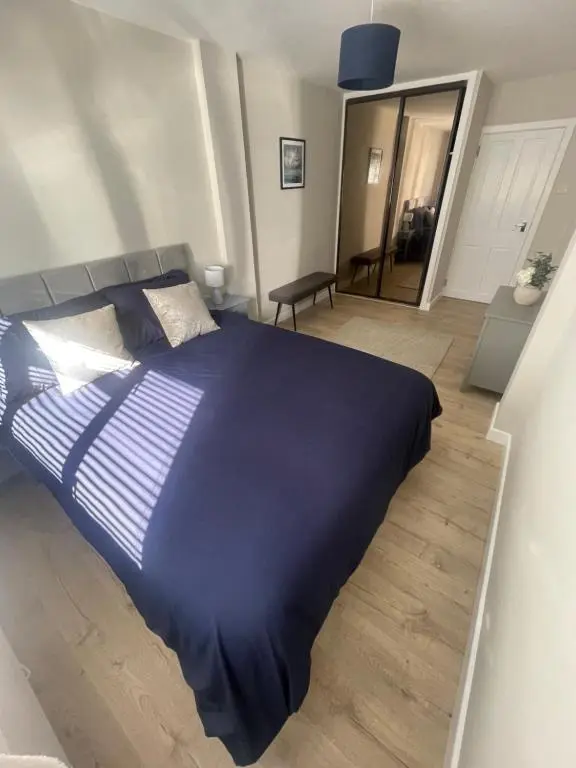 a large blue bed in a bedroom with a wooden floor at 51 Island Bank in Inverness