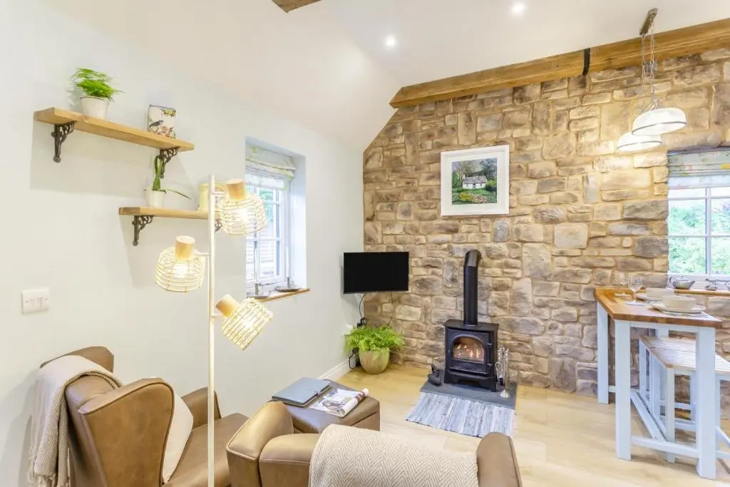 a living room with a stone wall and a wood stove at 1 Bed in Drumnadrochit oc-t32404 in Drumnadrochit
