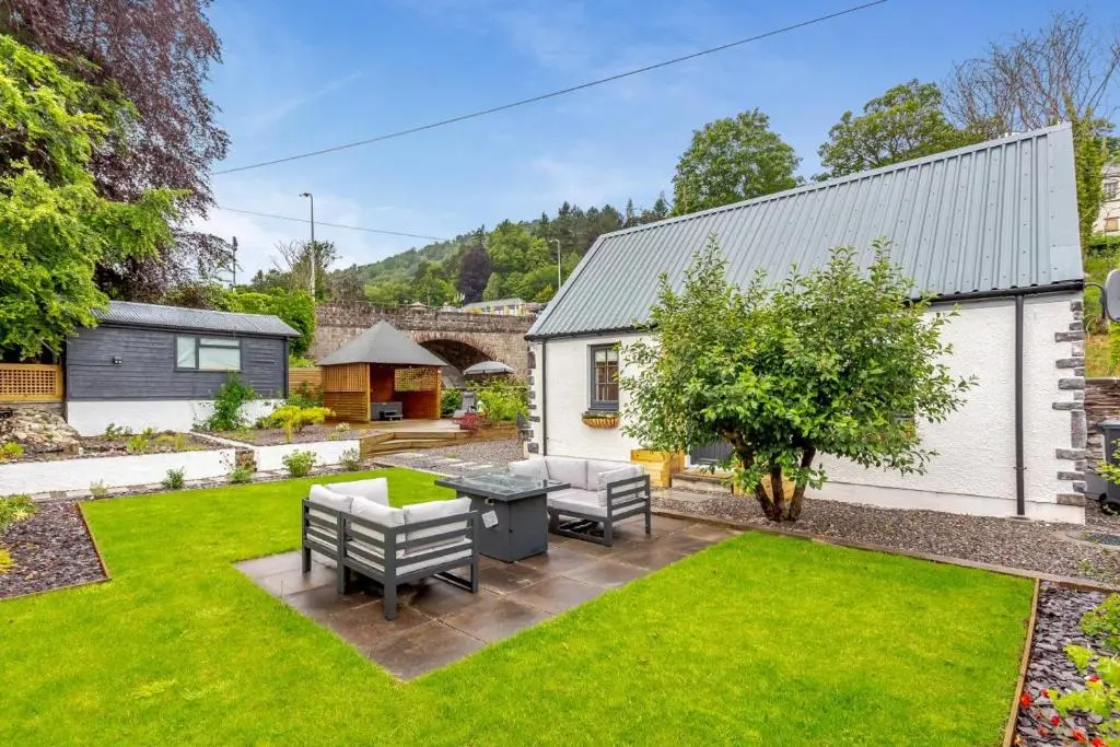 a garden with a table and chairs in a yard at 1 Bed in Drumnadrochit oc-t32404 in Drumnadrochit