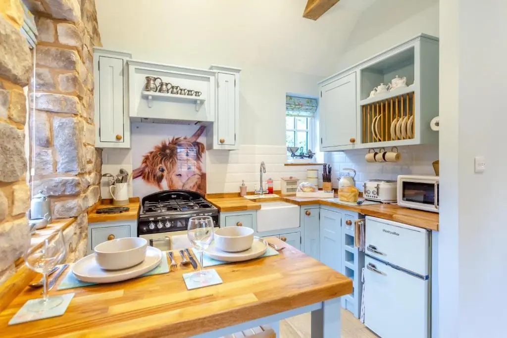 a kitchen with white cabinets and a wooden counter top at 1 Bed in Drumnadrochit oc-t32404 in Drumnadrochit
