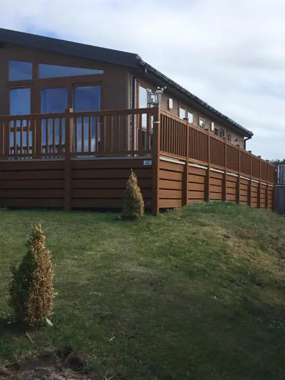 a house on a hill with a fence at Rivendale Lodge in Burghead