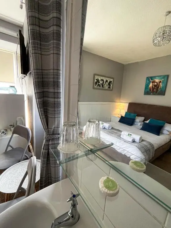 a bedroom with a bed and a glass table at Crown and Anchor Inn in Findhorn