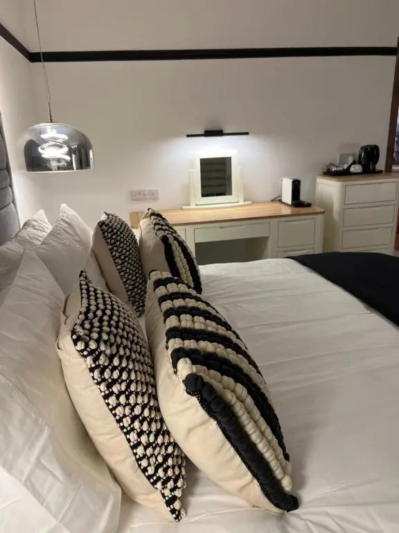 a white bed with four pillows on it at Druid House B&B in Inverness