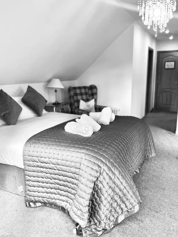 a bedroom with a large bed with two towels on it at Druid House B&B in Inverness